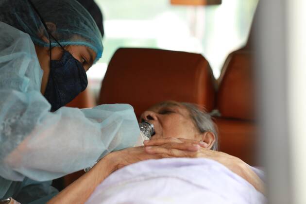 April 9, 2021, Dhaka, Dhaka, Bangladesh: April, 09,2021 A relative of a woman who has infected by the COVID-19 and she wearing a protective suit help to drink water to elderly woman in an ambulance, Dhaka, Bangladesh Dhaka Bangladesh - ZUMAr338 20210409_zip_r338_018 Copyright: xHarun-Or-Rashidx