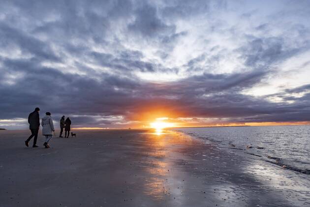 Menschen spazieren bei Sonnenuntergang am Strand, Langeoog, Ostfriesische Inseln, Niedersachsen, Deutschland, Europa Copyright: imageBROKER/JanxTepass ibxjte06732158