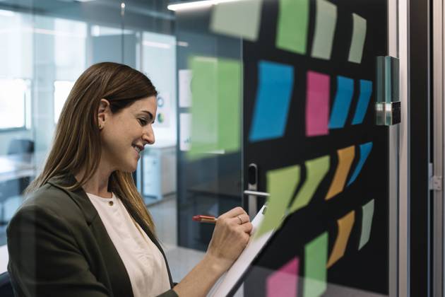 IMAGO Creative: Kreative Renaissance -- der junge Entrepreneur Female entrepreneur planning strategies while standing near glass wall with adhesive note at office model released Symbolfoto property released XLGF01417