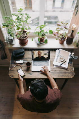 Businessman using smart phone while discussing with colleague on video call at home office Sweden, Stockholm, model released, property released Copyright: xMaskotx , MA86233