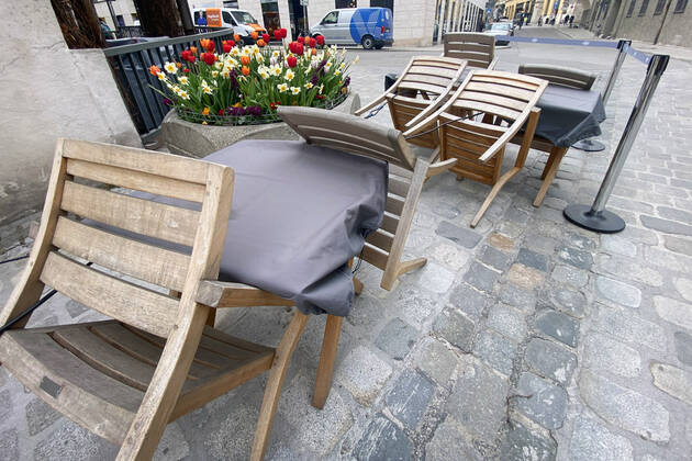 Themenbild: Coronavirus Pandemie Folgen fuer die Gastronomie: Umgeklappte Stuehle lehnen an Tischen vor einem Restaurant in Muenchen,Aussengastronomie.