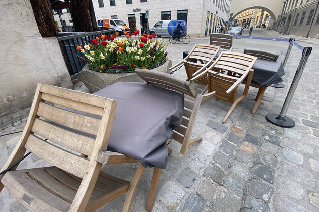 Themenbild: Coronavirus Pandemie Folgen fuer die Gastronomie: Umgeklappte Stuehle lehnen an Tischen vor einem Restaurant in Muenchen,Aussengastronomie.