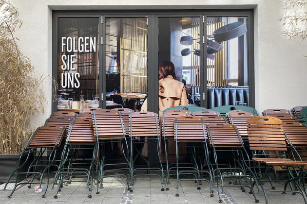 Themenbild: Coronavirus Pandemie Folgen fuer die Gastronomie: Uebereinander gestapelte Stuehle und Tische lehnen an der Hauswand von einem Restaurant in Muenchen,