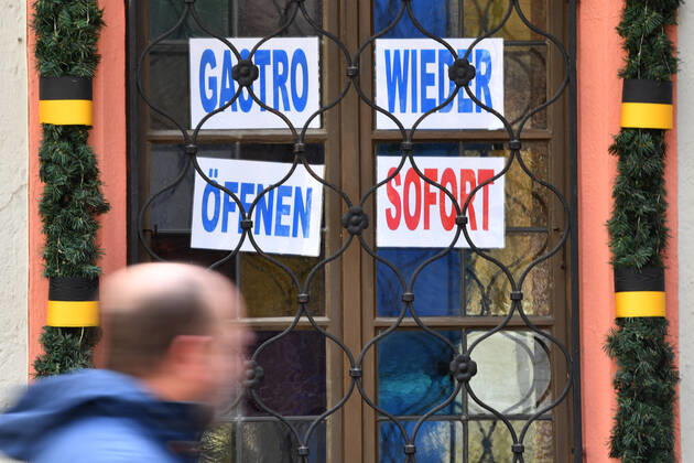 Themenbild: Coronavirus Pandemie Folgen fuer die Gastronomie: GASTRO WIEDER OEFFNEN SOFORT Im Fenster eines bayerischen Restaurants in Muenchen fordern die Eigentuemer die sofortige Oeffnung der Gastronomie. Passanten gehen mit Mundschutz,Maske vorbei.
