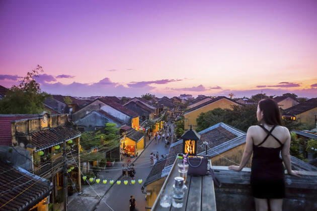 IMAGO Creative: Urbane Kultur - Sommer auf den Dächern Tourists walk down the colonial streets in historic old town Hoi An. Chinese lanterns illuminate the walkways as tourists watch the sunset from a rooftop restaurant; Hoi An, Quang Nam, Vietnam  Copyright: MicahxWright 33338936