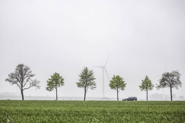 IMAGO Creative: Corporate: Klimaschutz, Digitalisierung und Urbanisierung Ein Auto zeichnet sich auf einer Landstrasse von Windraedern ab in Vierkirchen, 13.05.2021. Vierkirchen Deutschland