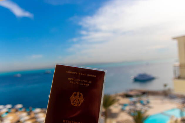 Reisepass der Bundesrepublik Deutschland vor einem unscharfen Urlaubshintergrund