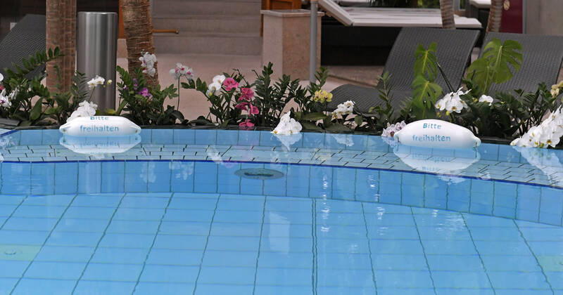 18.05.2021, Bad Wörishofen, 300 Tage im Corona-Lockdown, die Therme in Bad Wörishofen nutzt die Zeit ohne Gäste um umfangreiche Renovierungen und Neubauten zu realisieren. Geschäftsführer Jörg Wund hofft auf bald sinkende Infektionszahlen um Aussicht auf Wiedereröffnung zu haben. Die Therme musste bisher einen Umsatzrückgang von 12 Millionen Euro verkraften. Hier der Saunabereich mit den Palmen und Orchideen am Beckenrand und Bitte Freihalten Schilder 18.05.2021, Bad Wörishofen Therme 300 Tage im Lockdown 18.05.2021, Bad Wörishofen Therme 300 Tage im Lockdown