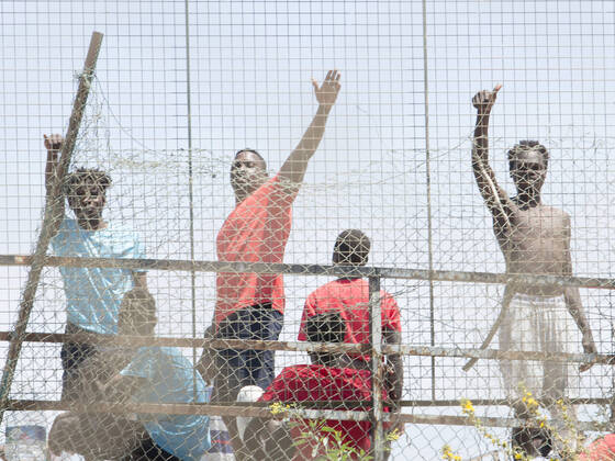 Several migrants behind a fence at the Ciudad del Altos del Real football stadium on May 18, 2021, in Melilla, Spain. A total of 86 migrants of sub-Saharan origin -- 85 men and one woman -- have entered Melilla on Tuesday along the southern seawall of the nearest coast that separates the Spanish city from Morocco, hours after thousands of Moroccans entered Ceuta, in an action in which three civil guards and a woman have been injured by the aggressiveness shown by those who entered using stones. The migrants arrived today in Melilla have been transferred from the Temporary Stay Centre for Immigrants (CETI) to the Altos del Real Football City, where they are now. 18 MAY 2021;CEUTA;MIGRATION CRISIS;MELILLA;MOROCCO;SUB-SAHARAN Ãngela Rios L Copyright: xÃngelaxRiosx 3718725