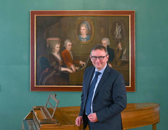 Pressekonferenz zur Programmpräsentation der Mozartwooche 2022 in Salzburg, am 19.05.21. Das Bild zeigt den Chief Market Officer der Internationalen Stiftung Mozarteum in Salzburg, Rainer Heneis, während einer Ansprache an die anwesenden Journalisten. Im Hintergrund ist ein Bild der Familie Mozart zu sehen. 2021 - Pressekonferenz zur Programmpräsentation der Mozartwooche 2022 in Salzburg, am 19.05.21