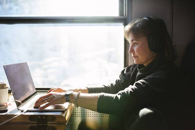 Businesswoman using laptop while sitting by window in train Sweden, Kiruna, model released Copyright: xMaskotx , MA86962