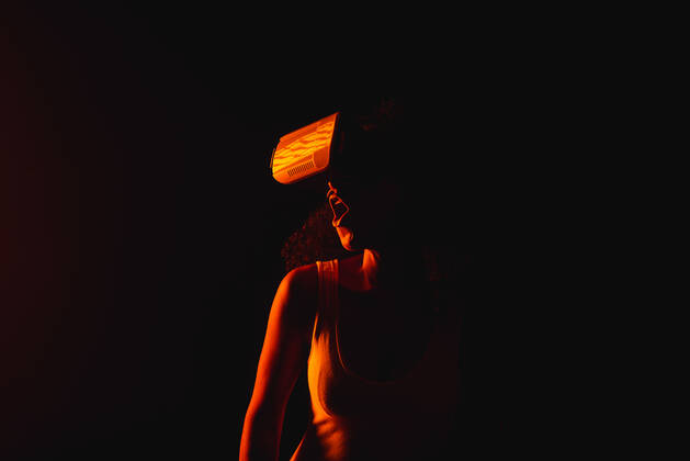 Anonymous astonished ethnic female with open mouth exploring virtual reality in headset on black background, Model released Copyright: xLeonardoxBorgesx MR