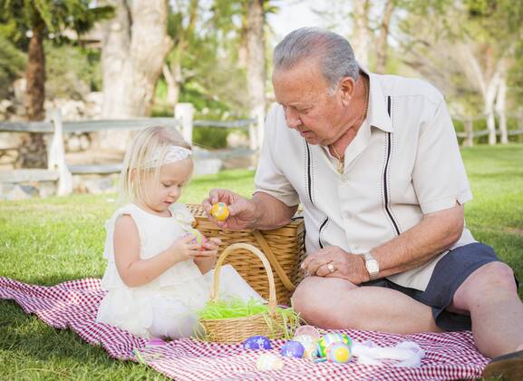 Liebevolle Großvater und Enkelin genießen Ostereier auf einer Picknickdecke im Park Copyright: imageBROKER/AndyxDean ibxdea06738201