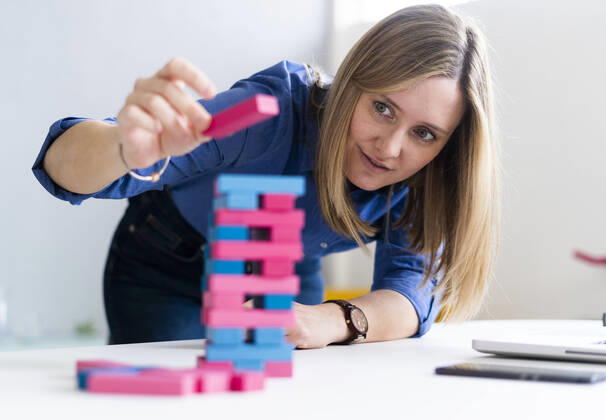 Businesswoman playing block removal game at office model released Symbolfoto property released GIOF12490