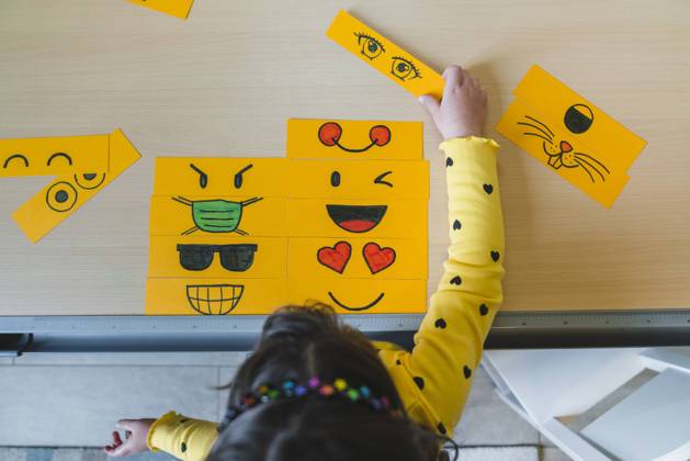 Girl playing with different emoticons on table at home model released Symbolfoto property released MGIF01061