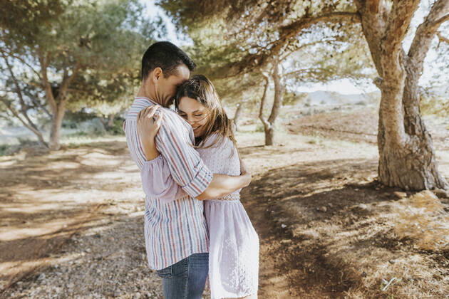 Smiling girlfriend embracing boyfriend outdoors model released Symbolfoto MIMFF00679