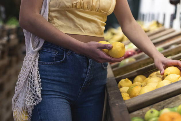 Woman holding lemons at store model released Symbolfoto property released PNAF01566