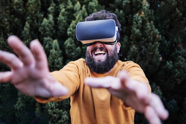 Playful man using VR glasses in garden model released Symbolfoto ASGF00316