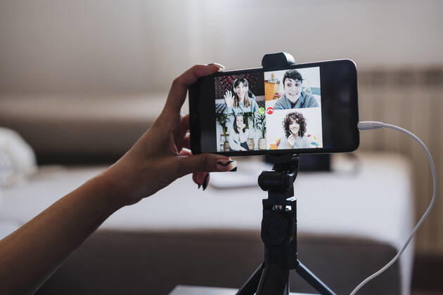 Woman video conferencing on smart phone at home model released Symbolfoto property released EBBF03868