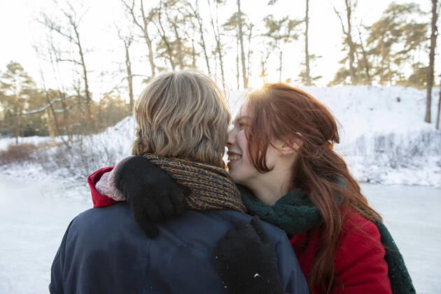 Smiling girlfriend embracing boyfriend during winter model released Symbolfoto FVDF00201