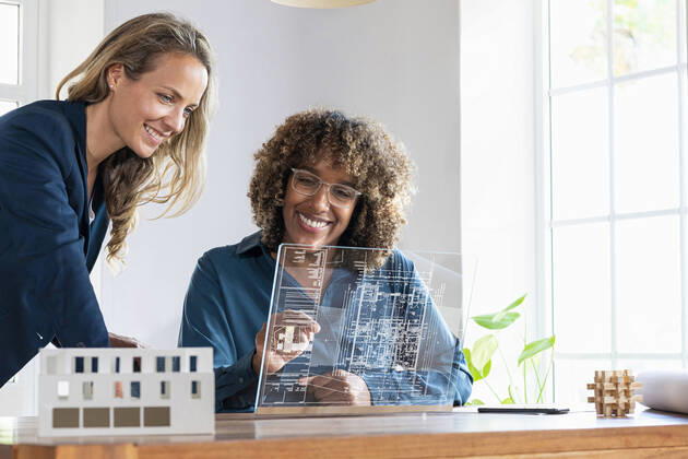 Mid adult businesswomen planning strategy on futuristic digital tablet at office model released Symbolfoto property released SBOF03979