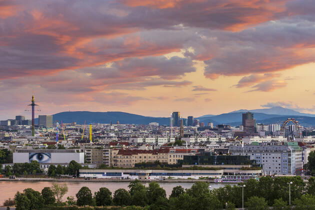 sunset panorama of Vienna city center from North-East: , river Donau (Danube), island Donauinsel, amusement park Prater, tower Praterturm (carousel type Starflyer), Ferris Wheel, mountain Schneeberg (right) Wien, Vienna Wien Austria 00. overview