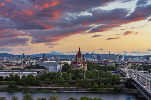 sunset panorama of Vienna city center from North-East: , river Donau (Danube), island Donauinsel, bridge Reichsbrücke, amusement park Prater, Ferris Wheel, church Franz von Assisi, cathedral Stephansdom (St. Stephen s Cathedral) (from left to right) Wien, Vienna Wien Austria 00. overview