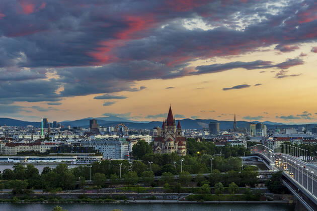 sunset panorama of Vienna city center from North-East: , river Donau (Danube), island Donauinsel, bridge Reichsbrücke, amusement park Prater, Ferris Wheel, church Franz von Assisi, cathedral Stephansdom (St. Stephen s Cathedral) (from left to right) Wien, Vienna Wien Austria 00. overview