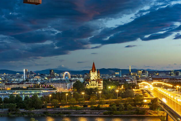 sunset panorama of Vienna city center from North-East: , river Donau (Danube), island Donauinsel, bridge Reichsbrücke, amusement park Prater, Ferris Wheel, church Franz von Assisi, cathedral Stephansdom (St. Stephen s Cathedral) (from left to right) Wien, Vienna Wien Austria 00. overview