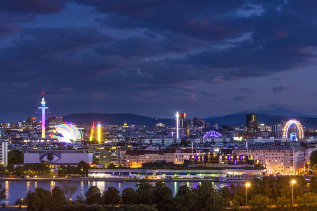 sunset panorama of Vienna city center from North-East: , river Donau (Danube), island Donauinsel, amusement park Prater, tower Praterturm (carousel type Starflyer), Ferris Wheel, mountain Schneeberg (right) Wien, Vienna Wien Austria 00. overview