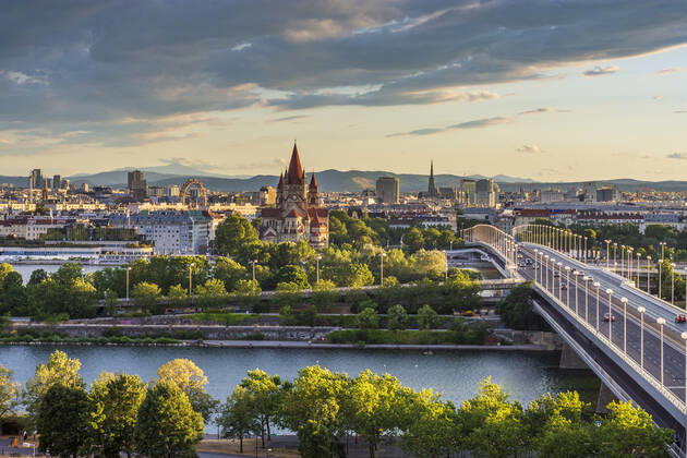 sunset panorama of Vienna city center from North-East: , river Donau (Danube), island Donauinsel, bridge Reichsbrücke, amusement park Prater, Ferris Wheel, church Franz von Assisi, cathedral Stephansdom (St. Stephen s Cathedral) (from left to right) Wien, Vienna Wien Austria 00. overview