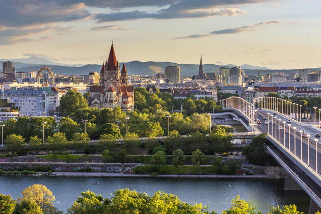 sunset panorama of Vienna city center from North-East: , river Donau (Danube), island Donauinsel, bridge Reichsbrücke, amusement park Prater, Ferris Wheel, church Franz von Assisi, cathedral Stephansdom (St. Stephen s Cathedral) (from left to right) Wien, Vienna Wien Austria 00. overview