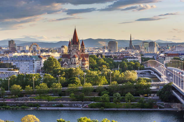 sunset panorama of Vienna city center from North-East: , river Donau (Danube), island Donauinsel, bridge Reichsbrücke, amusement park Prater, Ferris Wheel, church Franz von Assisi, cathedral Stephansdom (St. Stephen s Cathedral) (from left to right) Wien, Vienna Wien Austria 00. overview