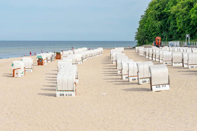 Ruegen, Sellin, Mecklenburg-Vorpommern, Germany - 10 june 2021: Holidaymakers go swimming on the beach of Sellin, several beach chairs to rest in the vacation area
