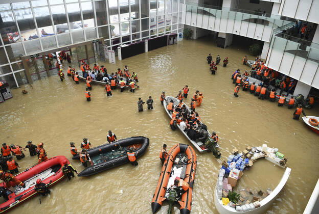 Bilder des Jahres 2021, News 07 Juli News Themen der Woche KW29 News Bilder des Tages China, Hochwasser in Zhengzhou (210722) -- ZHENGZHOU, July 22, 2021 -- Photo taken on July 22, 2021 shows people transferring patients in the flooded hall at the Fuwai Central China Cardiovascular Hospital in Zhongmu County of Zhengzhou, central China s Henan Province. The natural disaster has inflicted damage on many hospitals in Henan, with patients and medical staff stuck inside, waiting to be evacuated, including the Fuwai Central China Cardiovascular Hospital in the county of Zhongmu, under the jurisdiction of Zhengzhou, the provincial capital. Days of rainstorms have caused severe flooding in the hospital. On Thursday morning, rescuers started transporting patients, their family members and medical staff elsewhere. About 5,000 people have been evacuated so far.