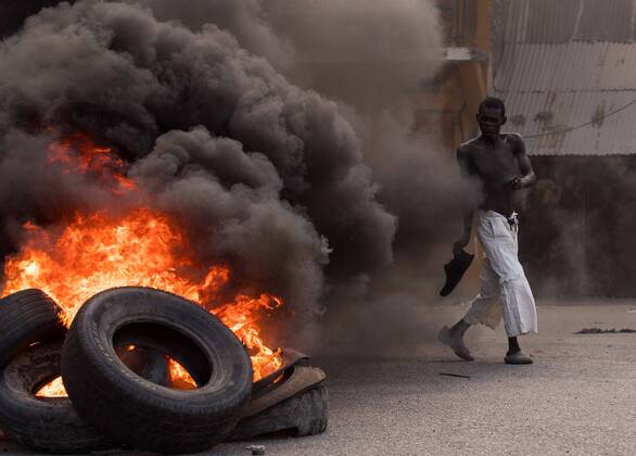 Bilder des Jahres 2021, News 07 Juli News Themen der Woche KW29 News Bilder des Tages A man walks in front of a pile of burning tires during a day of protests in Cap-Haitien, Haiti, 22 July 2021. Demonstrators demanding justice to Moise set up bonfires and barricades in different points of the city, at the northern of the country, where the latest president was born. Jovenel s staunch supporters do not want his funeral, scheduled for Friday, to take place until his murderers are dead. At the moment, 26 people have been arrested for their alleged involvement in the case. Haitians pay tribute assassinated President Jovenel Moise among protests !ACHTUNG: NUR REDAKTIONELLE NUTZUNG!  Copyright: xOrlandoxBarriax AME4469 20210722-47ca8439274c31b091c0e870edd0de6a1111270c