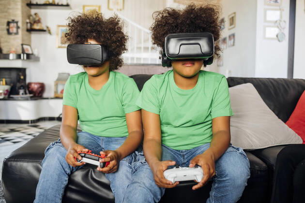 Twin brothers playing game wearing Virtual reality glasses at home model released Symbolfoto property released MEUF03416