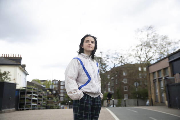 Young woman with hands in pockets standing in city model released Symbolfoto PMF01870