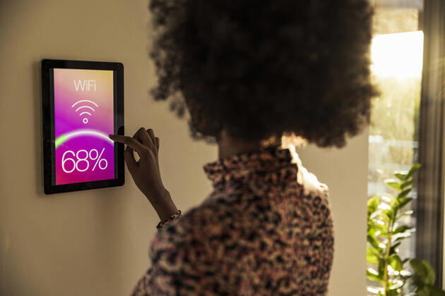 Woman using home automation device on wall model released Symbolfoto property released UUF23539