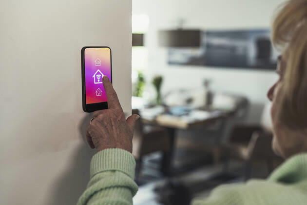 IMAGO Creative: Corporate: Klimaschutz, Digitalisierung und Urbanisierung Woman touching wifi icon on home automation device model released Symbolfoto property released UUF23651