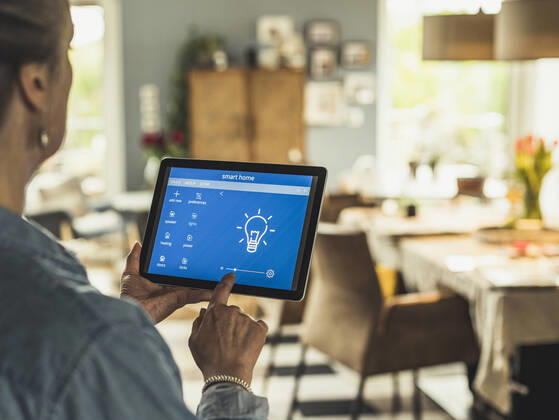 Woman operating home automation device through digital tablet at home model released Symbolfoto property released UUF23705