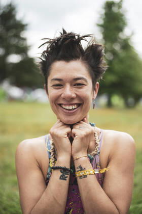 IMAGO Creative: Jahreszeit Sommer, Festivals IMAGO Creative: Jahreszeit Frühling, Picknick Smiling mixed-race asian woman with fun hair at festival in Poland Garbicz, Lubusz Voivodeship, Poland CR_PIDODS210721-787723-01 ,model released, Symbolfoto