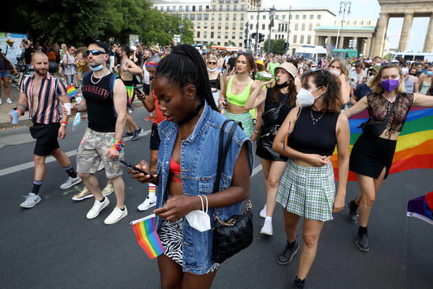 Berliner CHRISTOPHER STREET DAY 2021 - CSD - Am 24. Juli 2021 zieht der CSD in Berlin unter dem Motto SAVE OUR COMMUNITY SAVE YOUR PRIDE zum 43. Mal durch die Hauptstadt. Demoteilnehmerin trägt Regenbogenfähnchen im Demozug auf der Straße des 17. Juni. Die bunte CSD-Parade startete in diesem Jahr als Demonstration an der Leipziger Straße, führte über den Potsdamer Platz, vorbei am Denkmal für die im Nationalsozialismus verfolgten Homosexuellen zum Brandenburger Tor und über die Siegessäule zur Urania. Aufgrund der Corona-Pandemie fand die Demonstration ausschließlich unter Einhaltung der vom Berliner Senat erlassenen Vorgaben statt. Die in den Vorjahren übliche Abschlusskundgebung musste daher ausfallen.