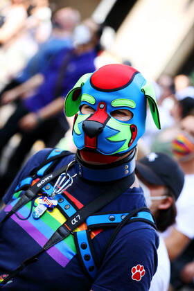 Berliner CHRISTOPHER STREET DAY 2021 - CSD - Am 24. Juli 2021 zieht der CSD in Berlin unter dem Motto SAVE OUR COMMUNITY SAVE YOUR PRIDE zum 43. Mal durch die Hauptstadt. Schwule Fetisch- und Lederszene im Demozug. Teilnehmer der Lederszene trägt Regenbogenflagge auf der Brust, ein Halsband und eine rot-blau-grüne Ledermaske. Die bunte CSD-Parade startete in diesem Jahr als Demonstration an der Leipziger Straße, führte über den Potsdamer Platz, vorbei am Denkmal für die im Nationalsozialismus verfolgten Homosexuellen zum Brandenburger Tor und über die Siegessäule zur Urania. Aufgrund der Corona-Pandemie fand die Demonstration ausschließlich unter Einhaltung der vom Berliner Senat erlassenen Vorgaben statt. Die in den Vorjahren