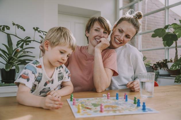IMAGO Creative: Herbst, in Gesellschaft spielen IMAGO Creative: Pride Month 2022, Engagement der Jugendlichen Mothers watching while son playing board game at home model released Symbolfoto property released MFF06660