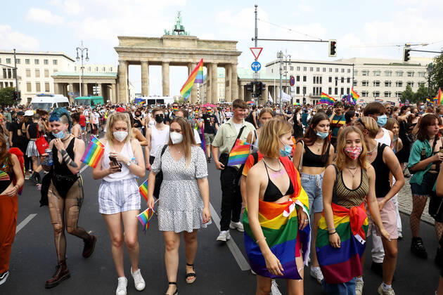 Berliner CHRISTOPHER STREET DAY 2021 - CSD - Am 24. Juli 2021 zieht der CSD in Berlin unter dem Motto SAVE OUR COMMUNITY Ð SAVE YOUR PRIDE zum 43. Mal durch die Hauptstadt. Zahlreiche Demoteilnehmer zum Teil mit Regenbogenflaggen und in Regenbogenfahnen gehüllt vor dem Brandenburger Tor. Die bunte CSD-Parade startete in diesem Jahr als Demonstration an der Leipziger Straße, führte über den Potsdamer Platz, vorbei am Denkmal für die im Nationalsozialismus verfolgten Homosexuellen zum Brandenburger Tor und über die Siegessäule zur Urania. Aufgrund der Corona-Pandemie fand die Demonstration ausschließlich unter Einhaltung der vom Berliner Senat erlassenen Vorgaben statt. Die in den Vorjahren übliche Abschlusskundgebung musste daher ausfallen.