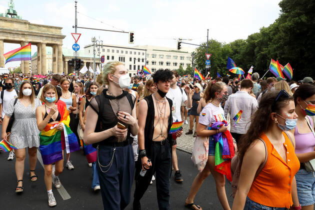 Berliner CHRISTOPHER STREET DAY 2021 - CSD - Am 24. Juli 2021 zieht der CSD in Berlin unter dem Motto SAVE OUR COMMUNITY Ð SAVE YOUR PRIDE zum 43. Mal durch die Hauptstadt. Zahlreiche Demoteilnehmer zum Teil mit Regenbogenflaggen und in Regenbogenfahnen gehüllt vor dem Brandenburger Tor. Die bunte CSD-Parade startete in diesem Jahr als Demonstration an der Leipziger Straße, führte über den Potsdamer Platz, vorbei am Denkmal für die im Nationalsozialismus verfolgten Homosexuellen zum Brandenburger Tor und über die Siegessäule zur Urania. Aufgrund der Corona-Pandemie fand die Demonstration ausschließlich unter Einhaltung der vom Berliner Senat erlassenen Vorgaben statt. Die in den Vorjahren übliche Abschlusskundgebung musste daher ausfallen.