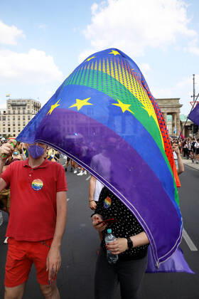 Berliner CHRISTOPHER STREET DAY 2021 - CSD - Am 24. Juli 2021 zieht der CSD in Berlin unter dem Motto SAVE OUR COMMUNITY Ð SAVE YOUR PRIDE zum 43. Mal durch die Hauptstadt. Demoteilnehmer vor dem Brandenburger Tor mit einem Mix aus Europaflagge und Regenbogenflagge. Die bunte CSD-Parade startete in diesem Jahr als Demonstration an der Leipziger Straße, führte über den Potsdamer Platz, vorbei am Denkmal für die im Nationalsozialismus verfolgten Homosexuellen zum Brandenburger Tor und über die Siegessäule zur Urania. Aufgrund der Corona-Pandemie fand die Demonstration ausschließlich unter Einhaltung der vom Berliner Senat erlassenen Vorgaben statt. Die in den Vorjahren übliche Abschlusskundgebung musste daher ausfallen.