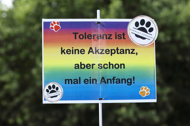 Berliner CHRISTOPHER STREET DAY 2021 - CSD - Am 24. Juli 2021 zieht der CSD in Berlin unter dem Motto SAVE OUR COMMUNITY Ð SAVE YOUR PRIDE zum 43. Mal durch die Hauptstadt. Protestschild mit der Aufschrift: Toleranz ist keine Akzeptanz, aber schon mal ein Anfang! - PUPPLAY GERMANY Die bunte CSD-Parade startete in diesem Jahr als Demonstration an der Leipziger Straße, führte über den Potsdamer Platz, vorbei am Denkmal für die im Nationalsozialismus verfolgten Homosexuellen zum Brandenburger Tor und über die Siegessäule zur Urania. Aufgrund der Corona-Pandemie fand die Demonstration ausschließlich unter Einhaltung der vom Berliner Senat erlassenen Vorgaben statt. Die in den Vorjahren übliche Abschlusskundgebung musste daher ausfallen.