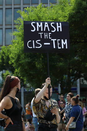 Berliner CHRISTOPHER STREET DAY 2021 - CSD - Am 24. Juli 2021 zieht der CSD in Berlin unter dem Motto SAVE OUR COMMUNITY SAVE YOUR PRIDE zum 43. Mal durch die Hauptstadt. Demoteilnehmer trägt Protestschild mit dem Schriftzug: SMASH THE CIS-TEM Die bunte CSD-Parade startete in diesem Jahr als Demonstration an der Leipziger Straße, führte über den Potsdamer Platz, vorbei am Denkmal für die im Nationalsozialismus verfolgten Homosexuellen zum Brandenburger Tor und über die Siegessäule zur Urania. Aufgrund der Corona-Pandemie fand die Demonstration ausschließlich unter Einhaltung der vom Berliner Senat erlassenen Vorgaben statt. Die in den Vorjahren übliche Abschlusskundgebung musste daher ausfallen.